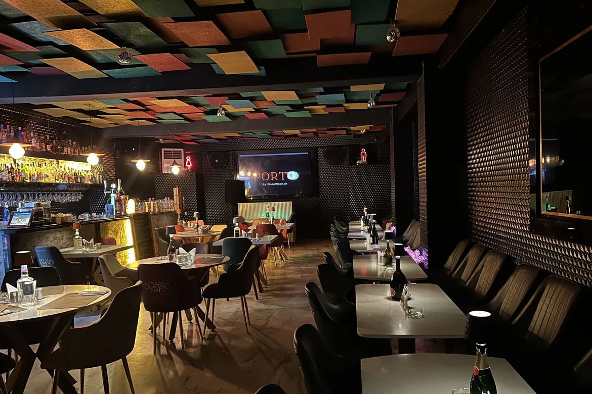 Porto: the bar, the marble tables and the ceiling of coloured panels.